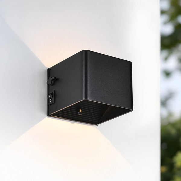 Pike black rechargeable outdoor wall light with motion sensor mounted beside door