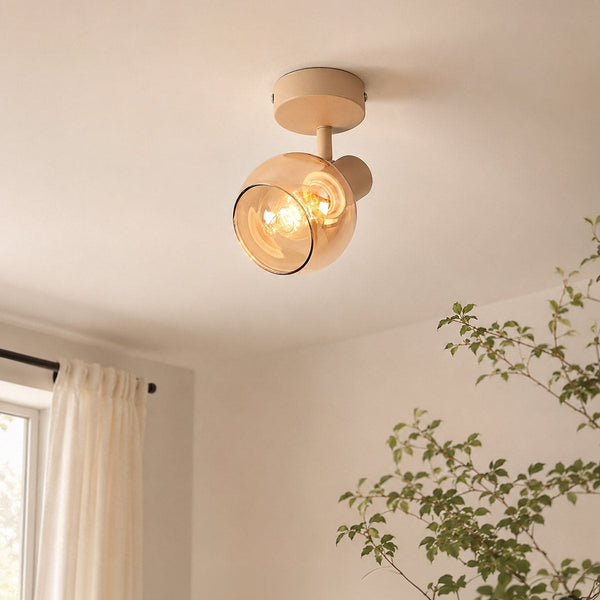 Beno adjustable ceiling spotlight with beige mount and amber glass shade