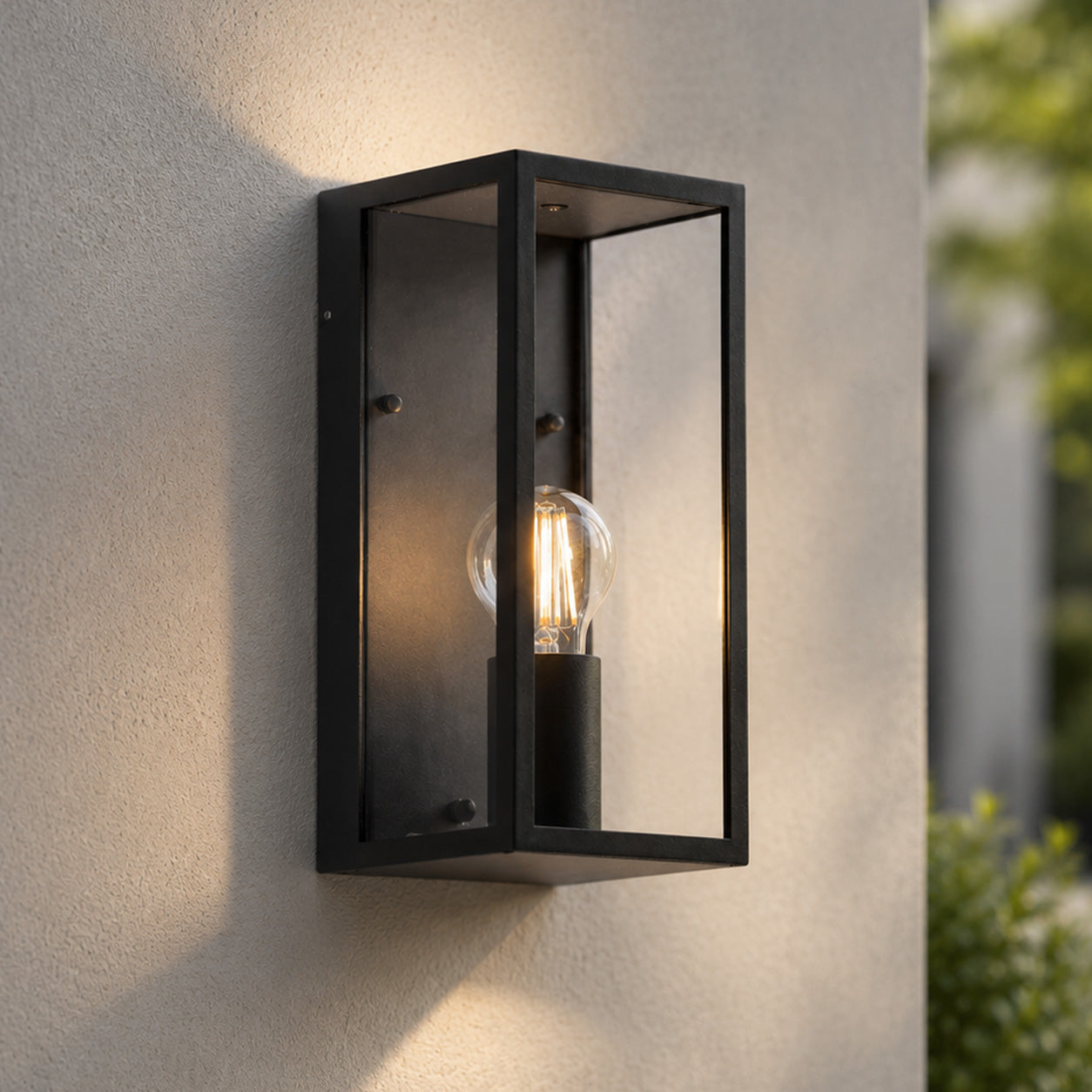 Mirage outdoor wall lantern in anthracite glowing warmly beside a door at dusk