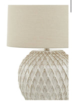 Close-up of intricate lattice detailing on cream ceramic lamp base