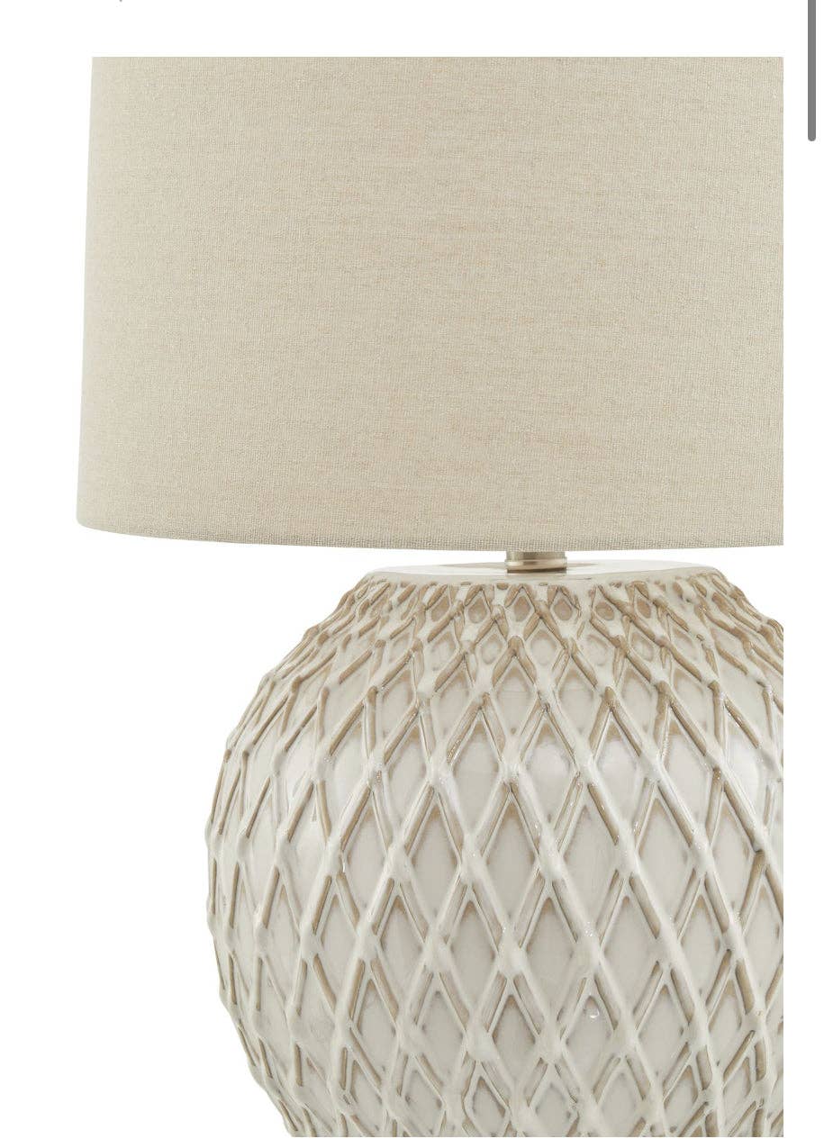 Close-up of intricate lattice detailing on cream ceramic lamp base