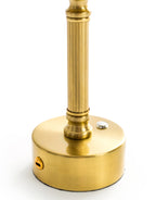 Close-up of Lira brass table lamp showing oatmeal shade and warm ambient glow