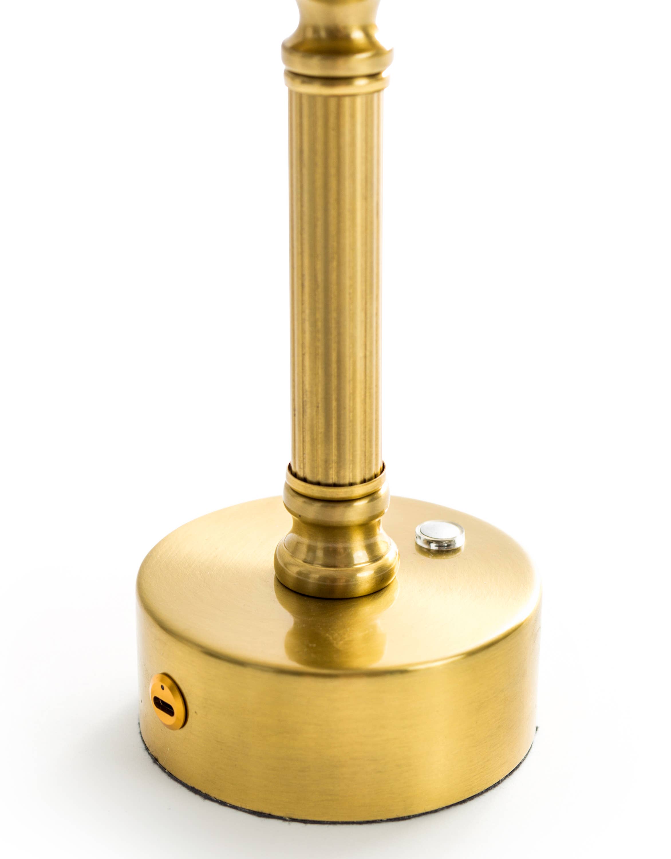 Close-up of Lira brass table lamp showing oatmeal shade and warm ambient glow