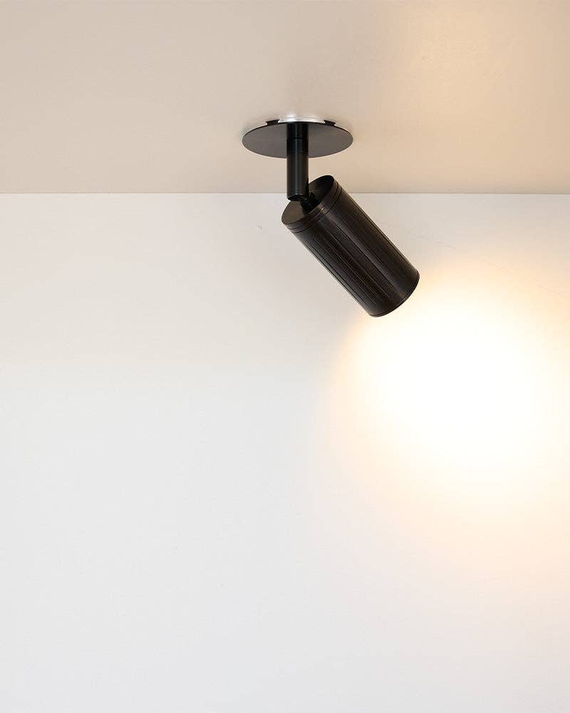 Close-up of gunmetal black architectural spotlight fixture showing precision ribbing