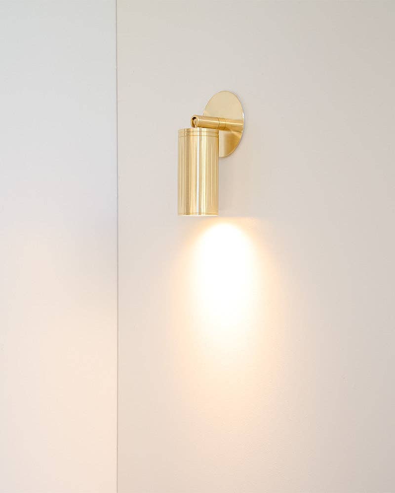 Luminar Box Mount brushed brass wall spotlight mounted on white wall