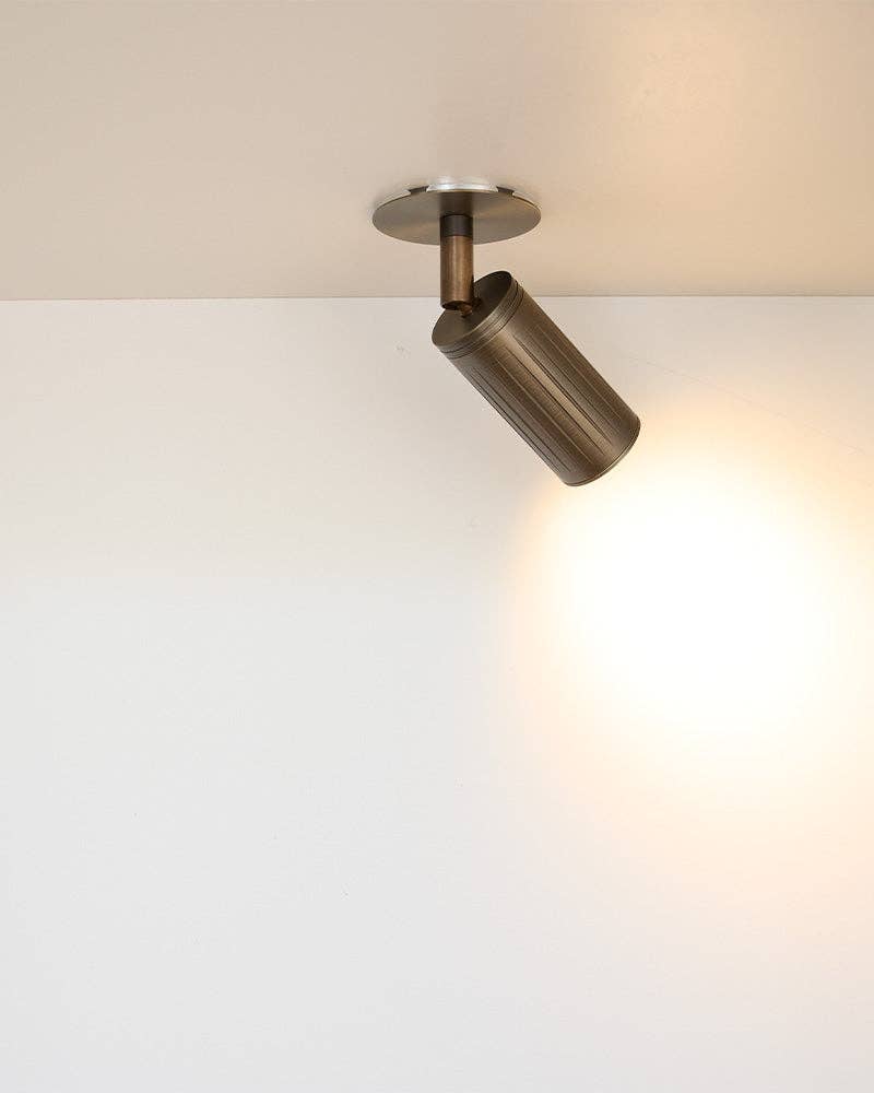 Close-up of browned brass directional spotlight showing precision-machined texture
