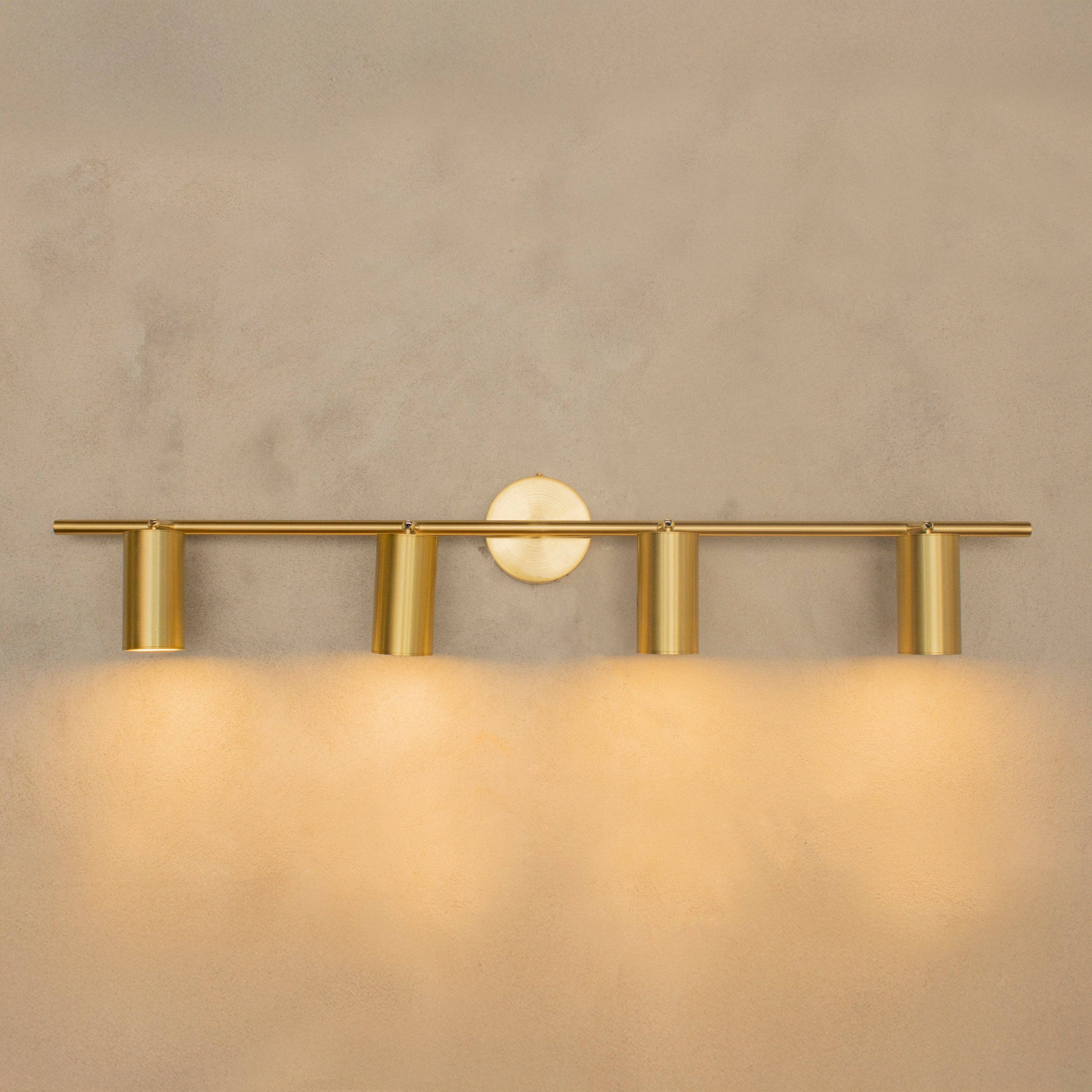 Koza antique brass wall sconce mounted on white wall