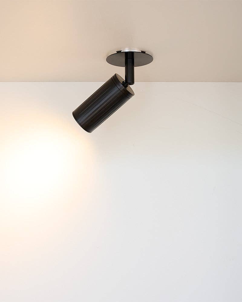 Box mount ceiling spotlight casting focused directional light beam