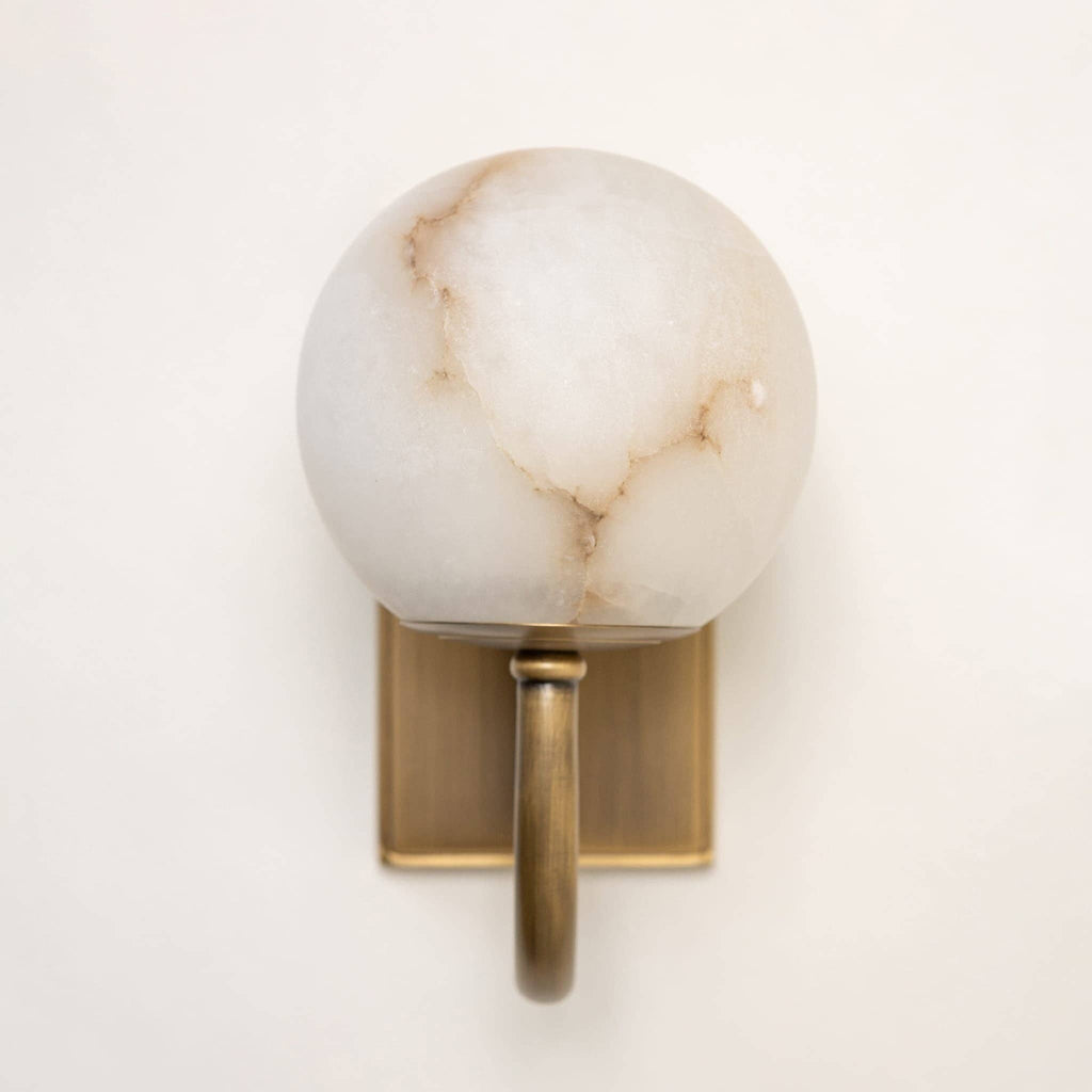 Natural alabaster sphere wall light showing cream tones and copper veining detail