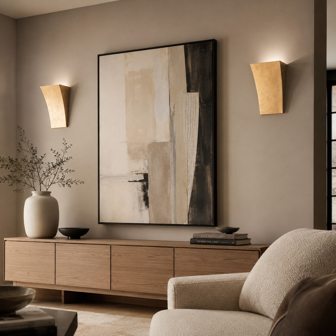 Alma gold leaf wall lights lit in a warm lounge with oak sideboard