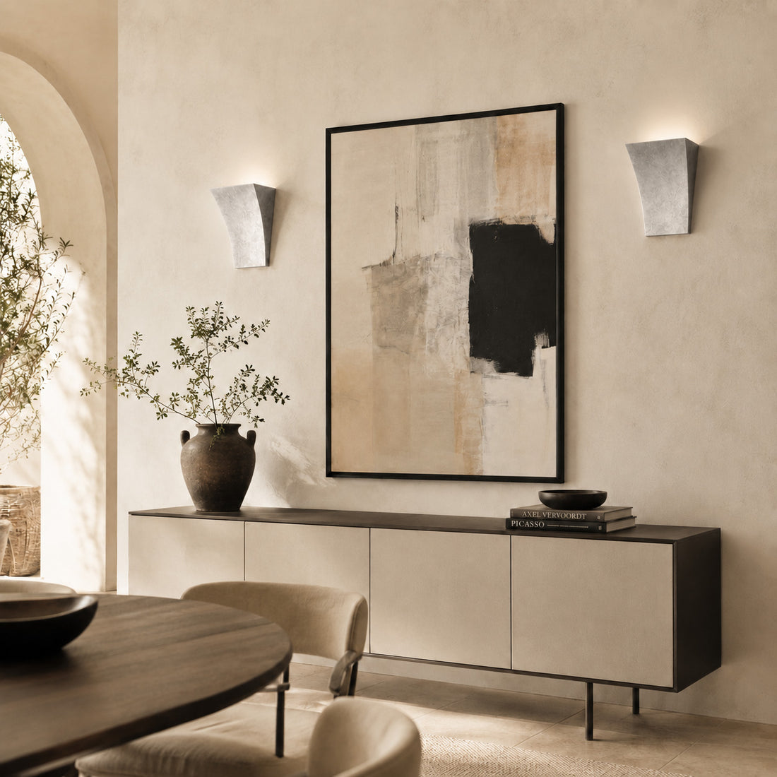 Alma silver leaf uplighters lit either side of framed art in a dining room