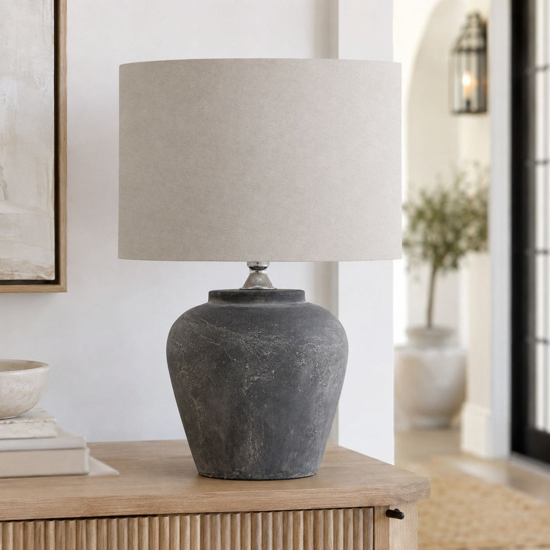 Amalfi grey urn table lamp on a wooden sideboard in a bright living room