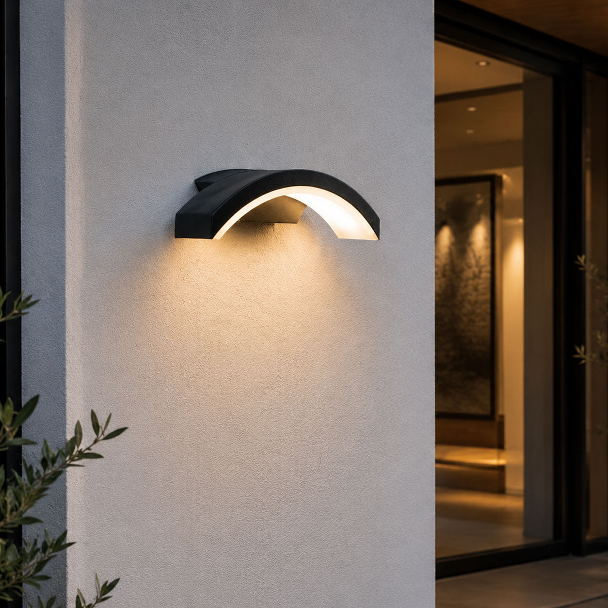 Arlen black arched LED wall light lit beside a modern front entrance at dusk