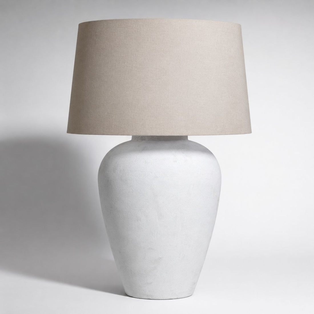 Athena tall aged stone urn table lamp with natural linen shade, on white