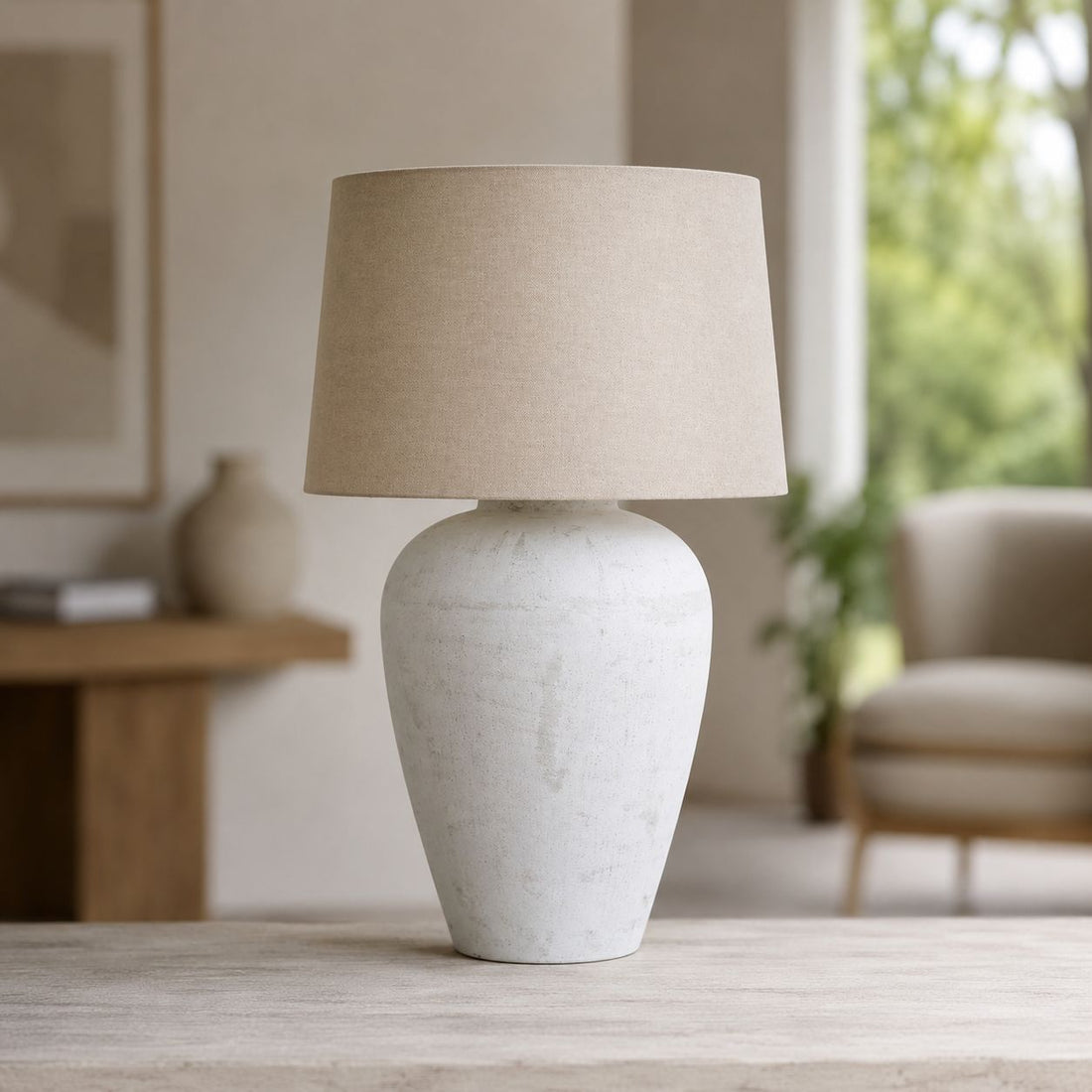 Athena tall white stone table lamp on a wooden sideboard in a neutral living room