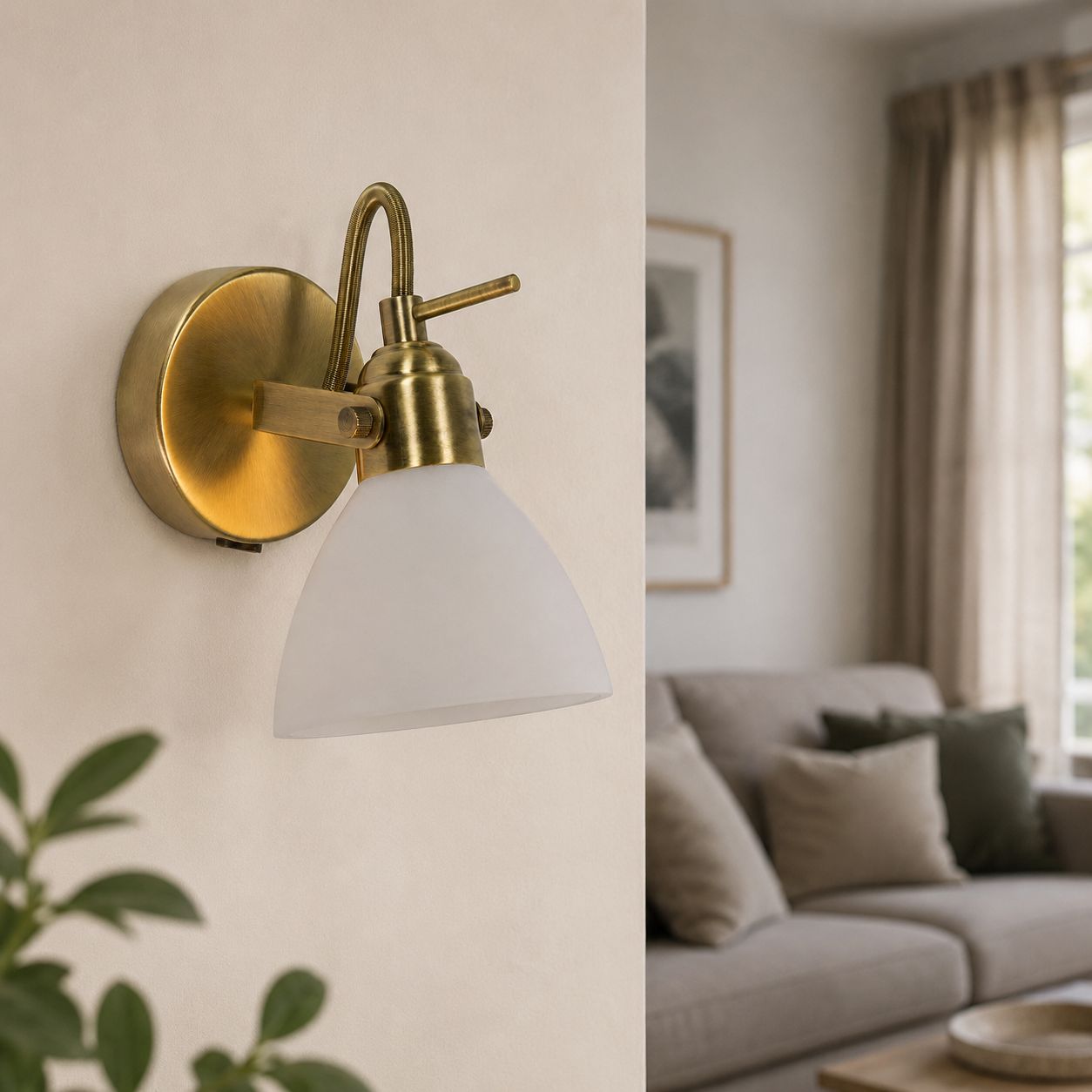 Callas antique brass wall spot light with opal glass shade lit in a living room