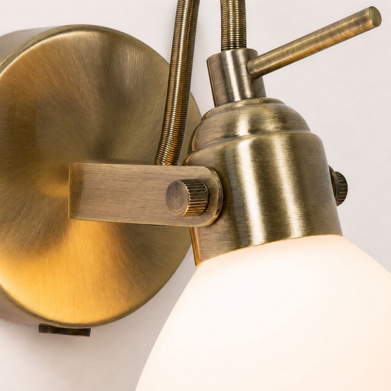 Callas wall spot light, close-up of the antique brass swan-neck and opal shade