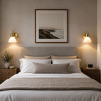 Two Callas antique brass opal shade wall lights either side of a bed