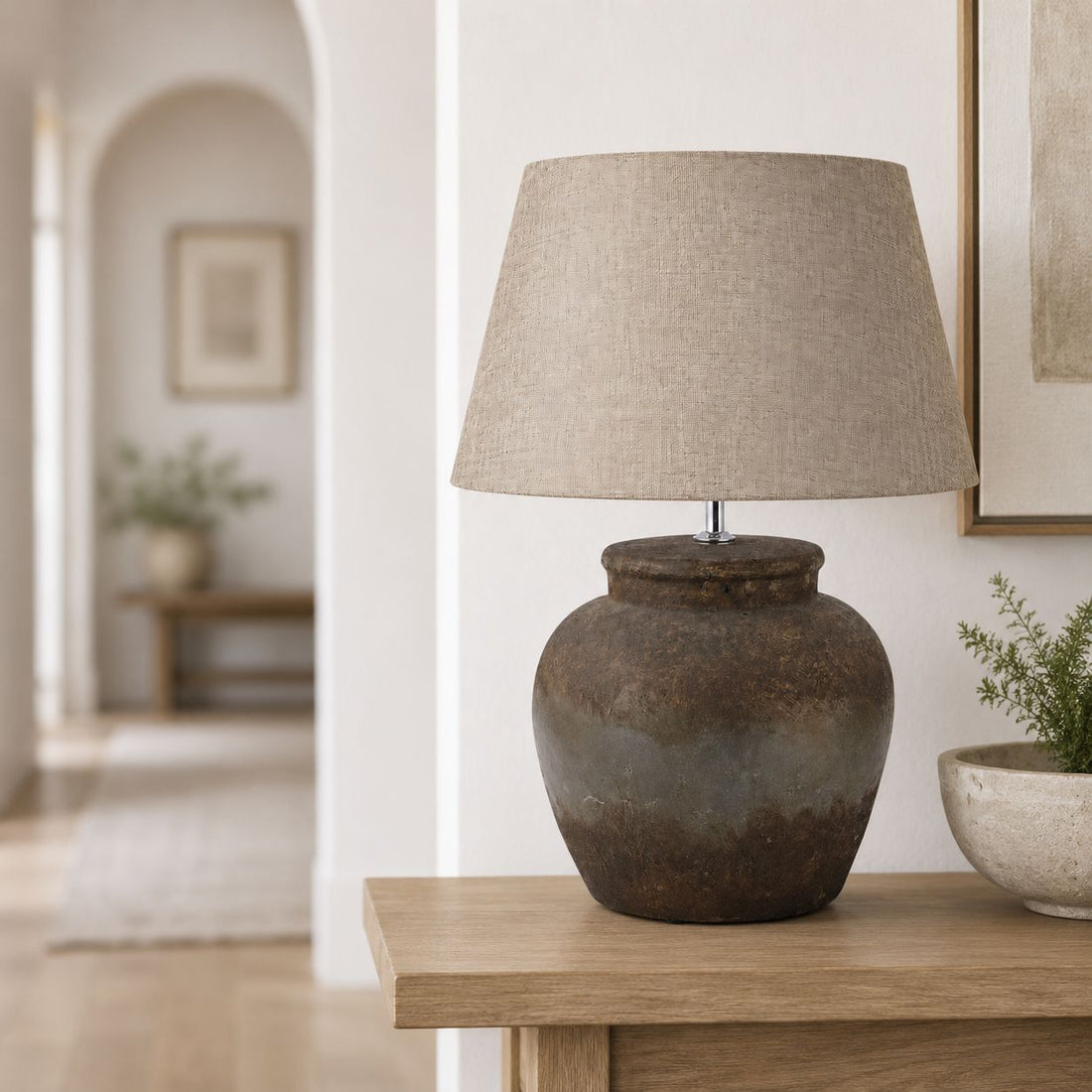 Castello aged stone urn lamp on a wooden side table in a bright living room