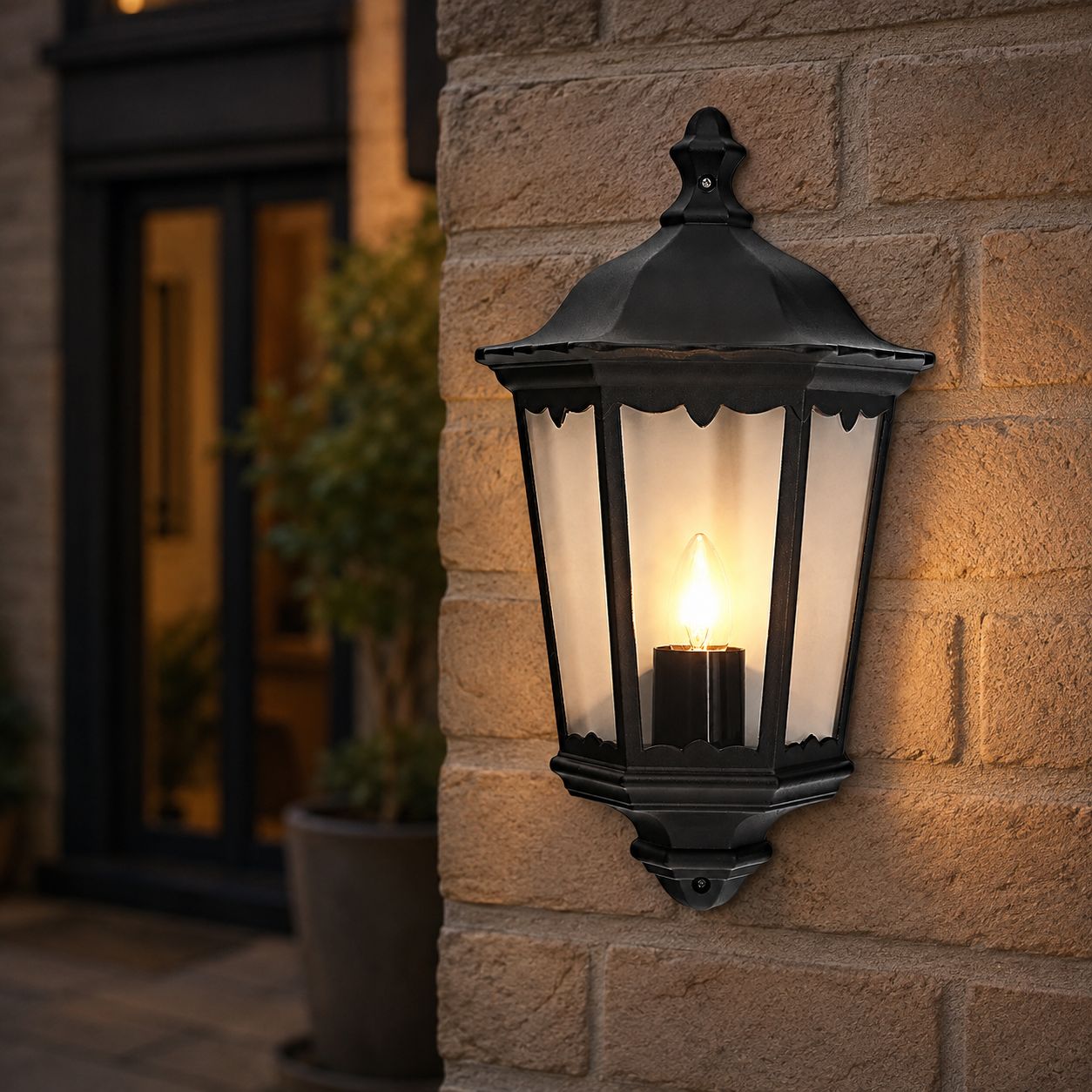 Corben matt black half lantern lit on a brick wall next to a front door
