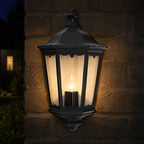 Corben black half lantern lit on a brick wall at dusk