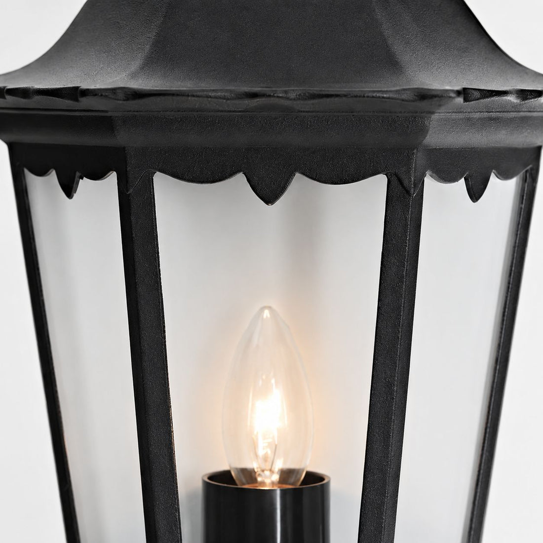 Corben half lantern, close-up of the candle-style bulb and clear glass panels