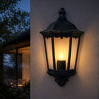 Corben matt black half lantern wall light lit at night beside a house