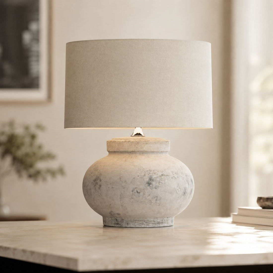 Darcy squat antique white table lamp on a console with framed art behind