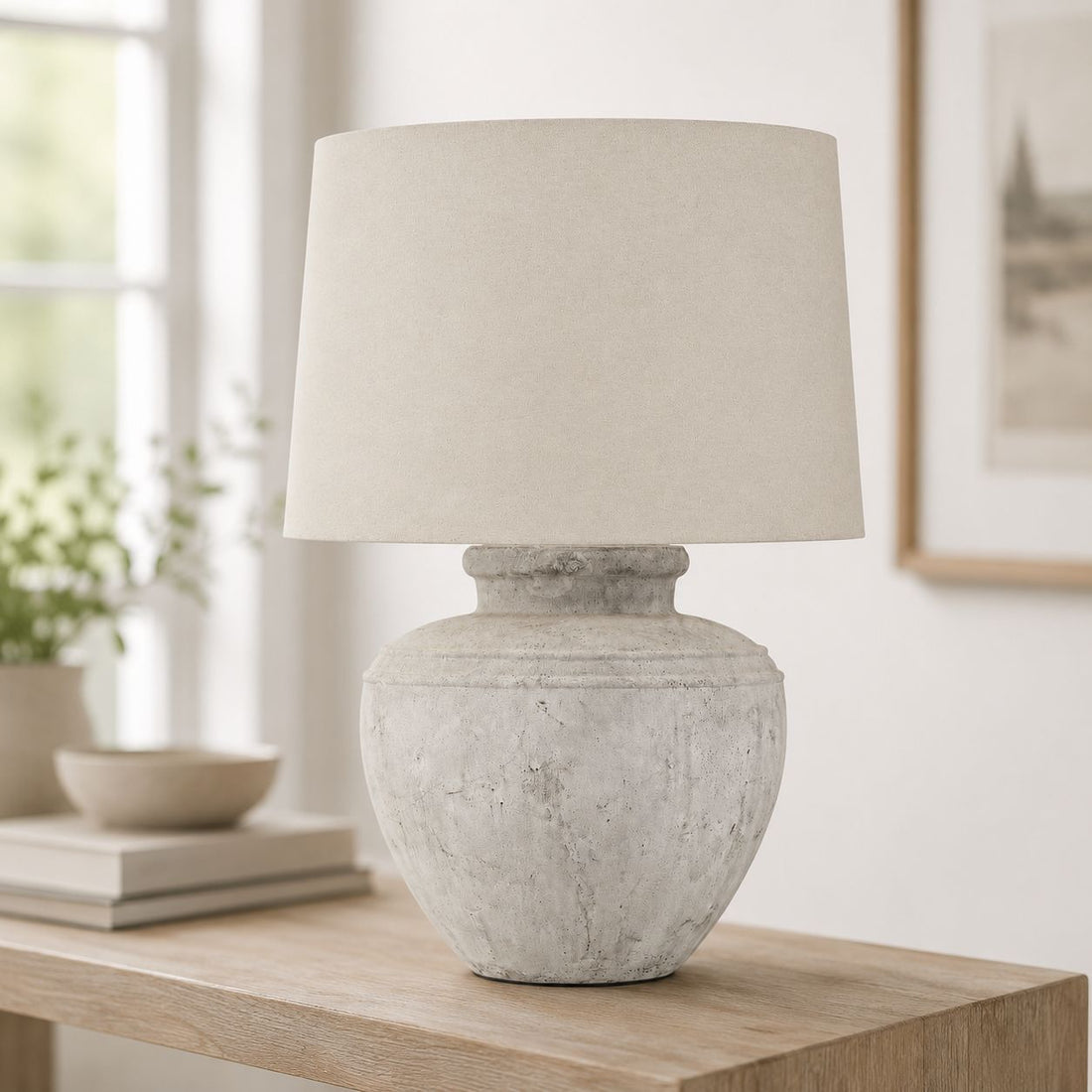 Darcy Chorus antique white table lamp on a console with framed art behind