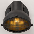 Forge caged wall spot light, close-up of the black mesh grille and lit bulb