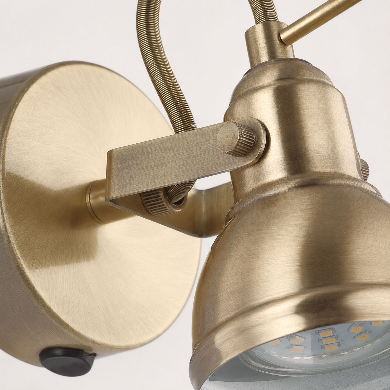 Harlow antique brass wall spot light, close-up of the swan-neck arm and spotlight head