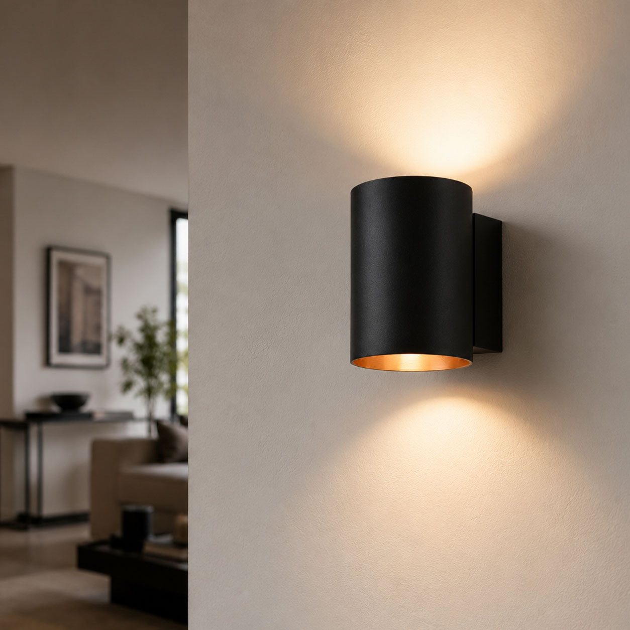 Jen black and gold cylinder wall light lit in a living room