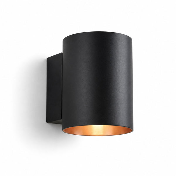 Jen round black up and down wall light with gold interior, angled view on white