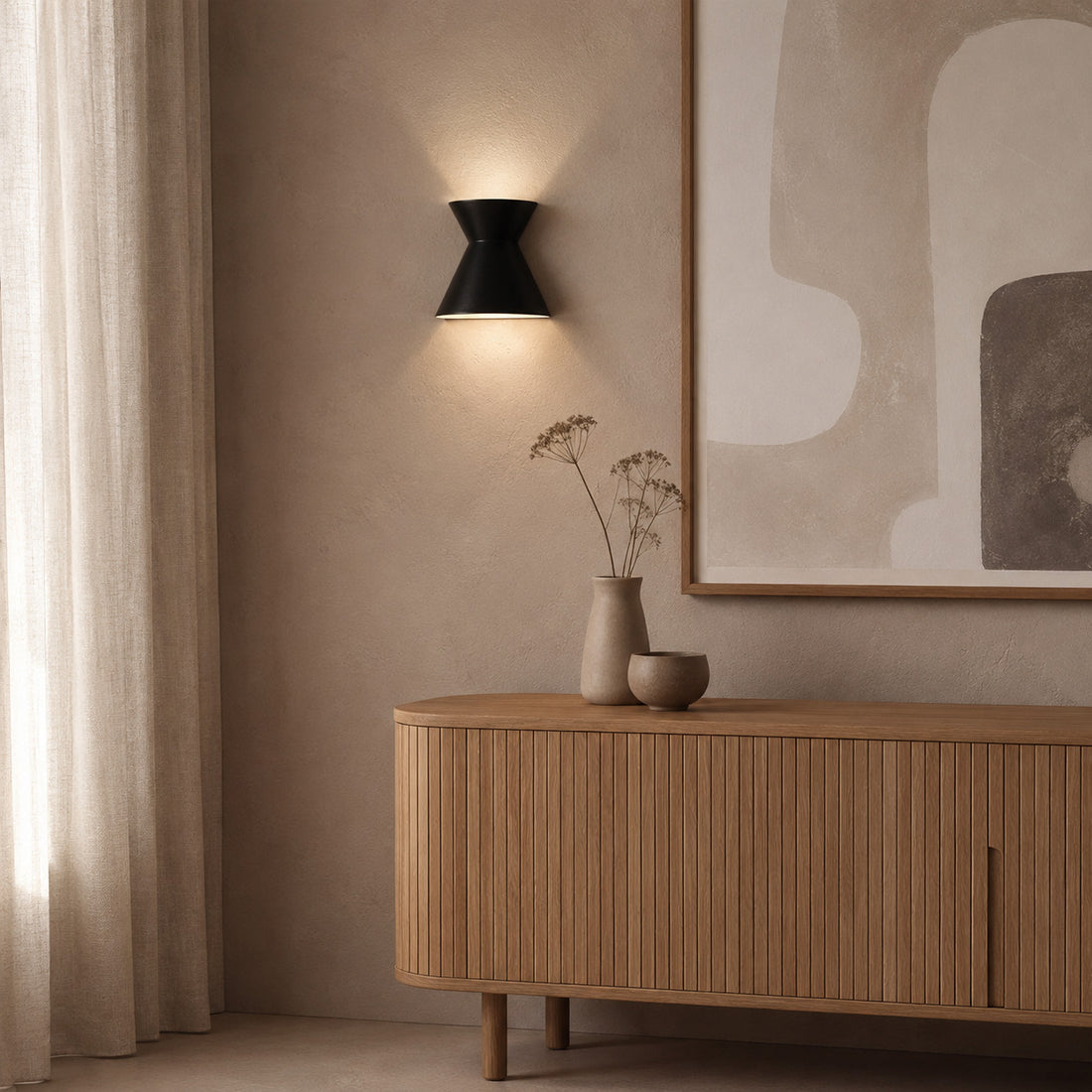 Small Kiro black sconce glowing by a linen curtain over an oak console