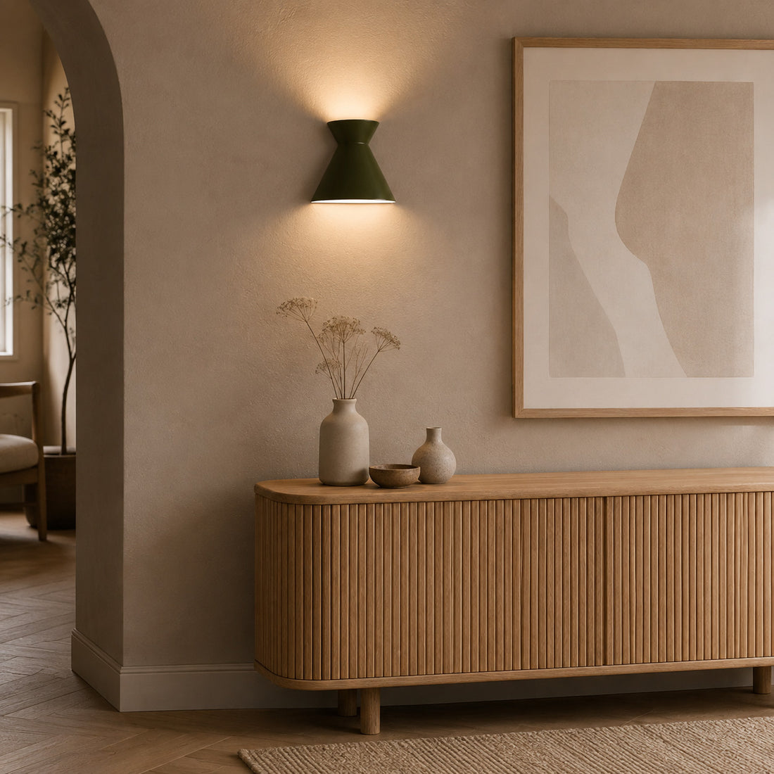Kiro moss green sconce lit under an arch above a fluted oak sideboard