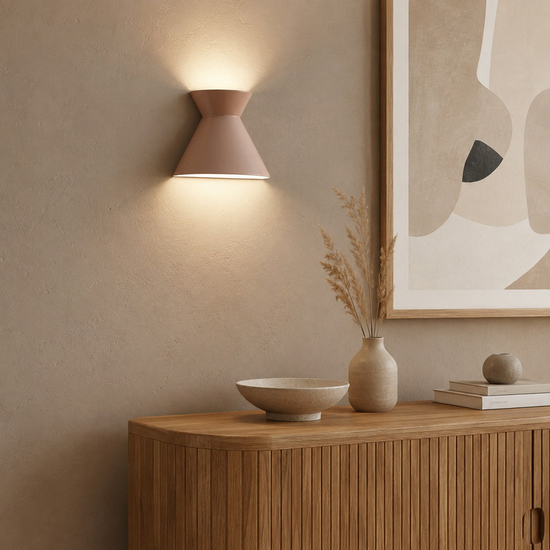 Kiro warm taupe ceramic sconce lit beside abstract art over a curved console