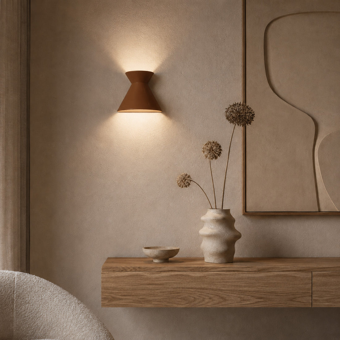 Kiro russet sconce lit beside dried allium stems on an oak shelf
