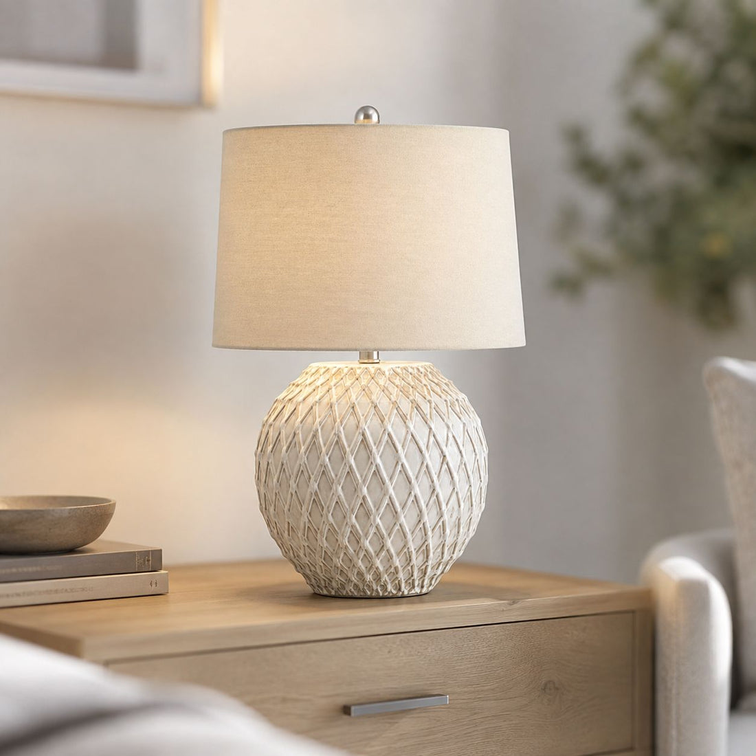 Lattice cream ceramic table lamp on a bedside table with linen shade