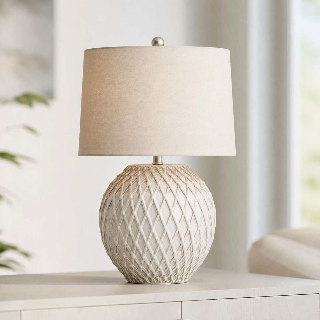 Lattice cream ceramic table lamp with linen shade on a console in a bright room