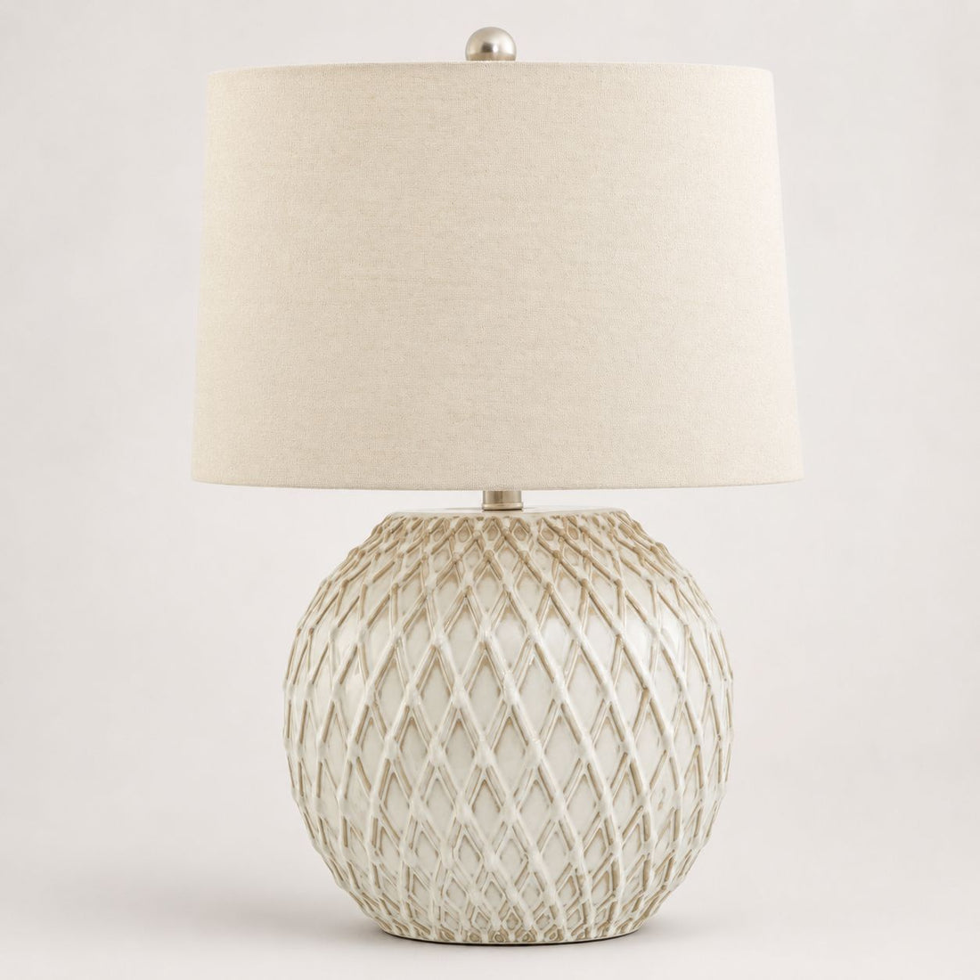 Lattice cream diamond-pattern ceramic table lamp with linen shade, on white