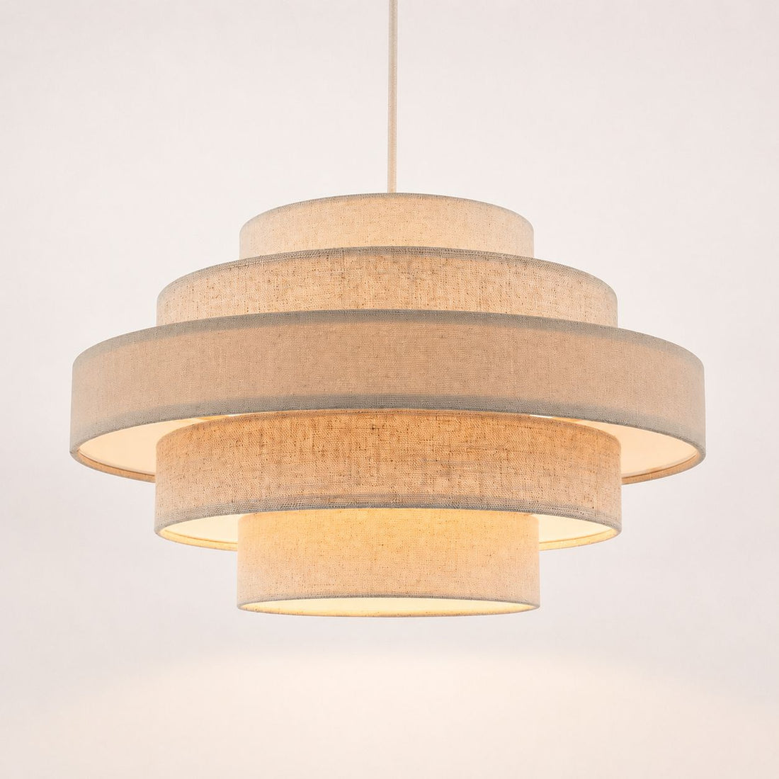 Linna oatmeal linen five-tier easy-fit pendant shade lit, angled view