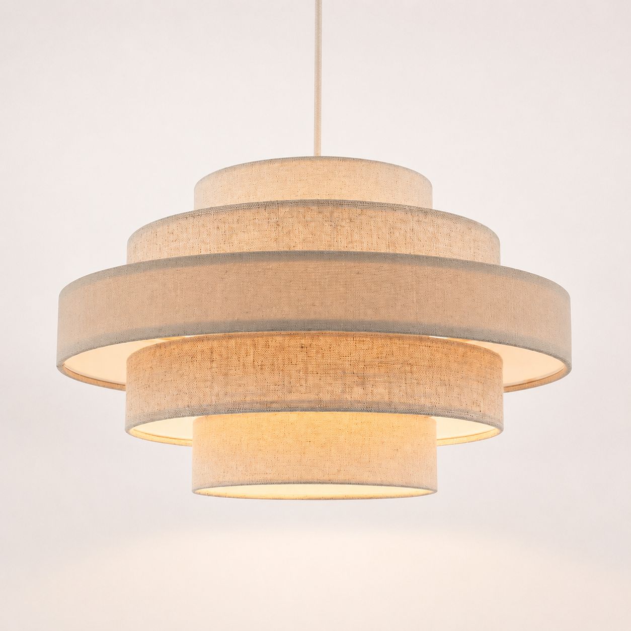 Linna oatmeal linen five-tier easy-fit pendant shade lit, angled view