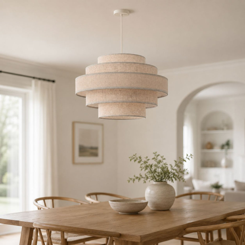 Linna oatmeal tiered linen pendant lit above a dining table in a bright room