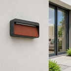 Loren anthracite and wood outdoor wall light on a rendered wall by a modern house in daylight