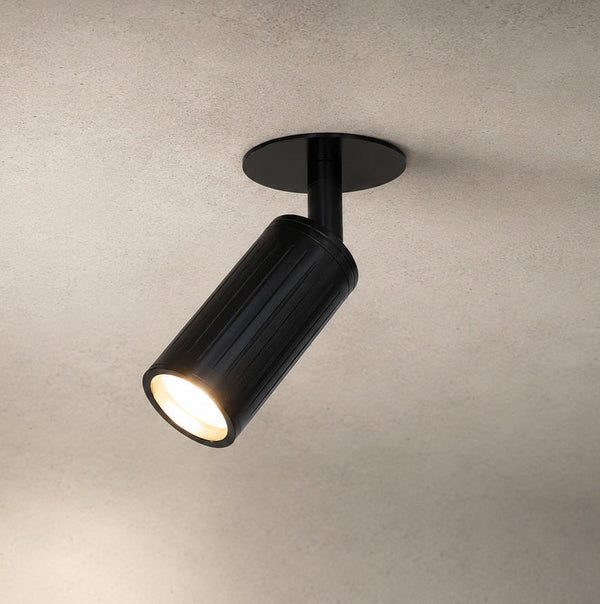 Luminar matt black ceiling spotlight tilted, lit with warm beam