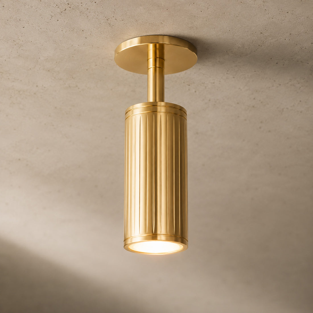 Luminar brushed brass ceiling spotlight pointing down, lit