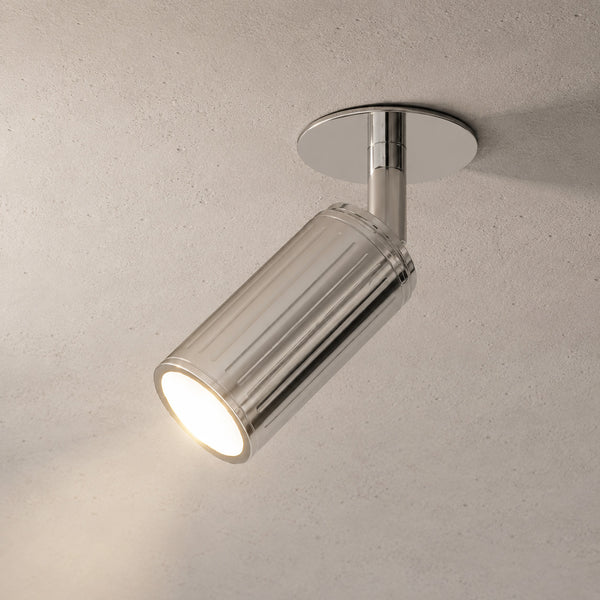 Luminar polished steel ceiling spotlight tilted, lit with bright beam