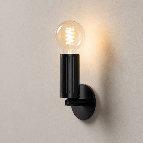 Luminar matt black wall lamp with exposed globe filament bulb, lit