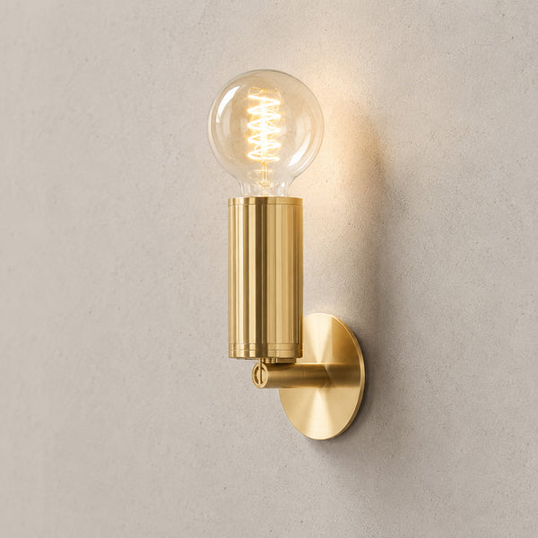 Luminar brushed brass wall lamp with exposed globe filament bulb, lit