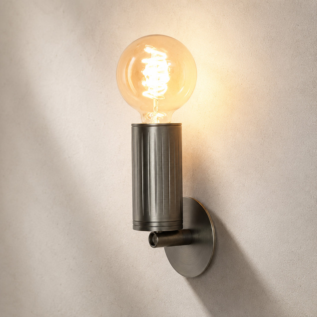 Luminar browned brass wall lamp with exposed spiral filament globe bulb, lit